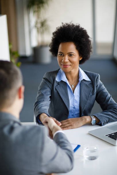 Smiling Afro American businesswoman and Caucasian businessman handshaking